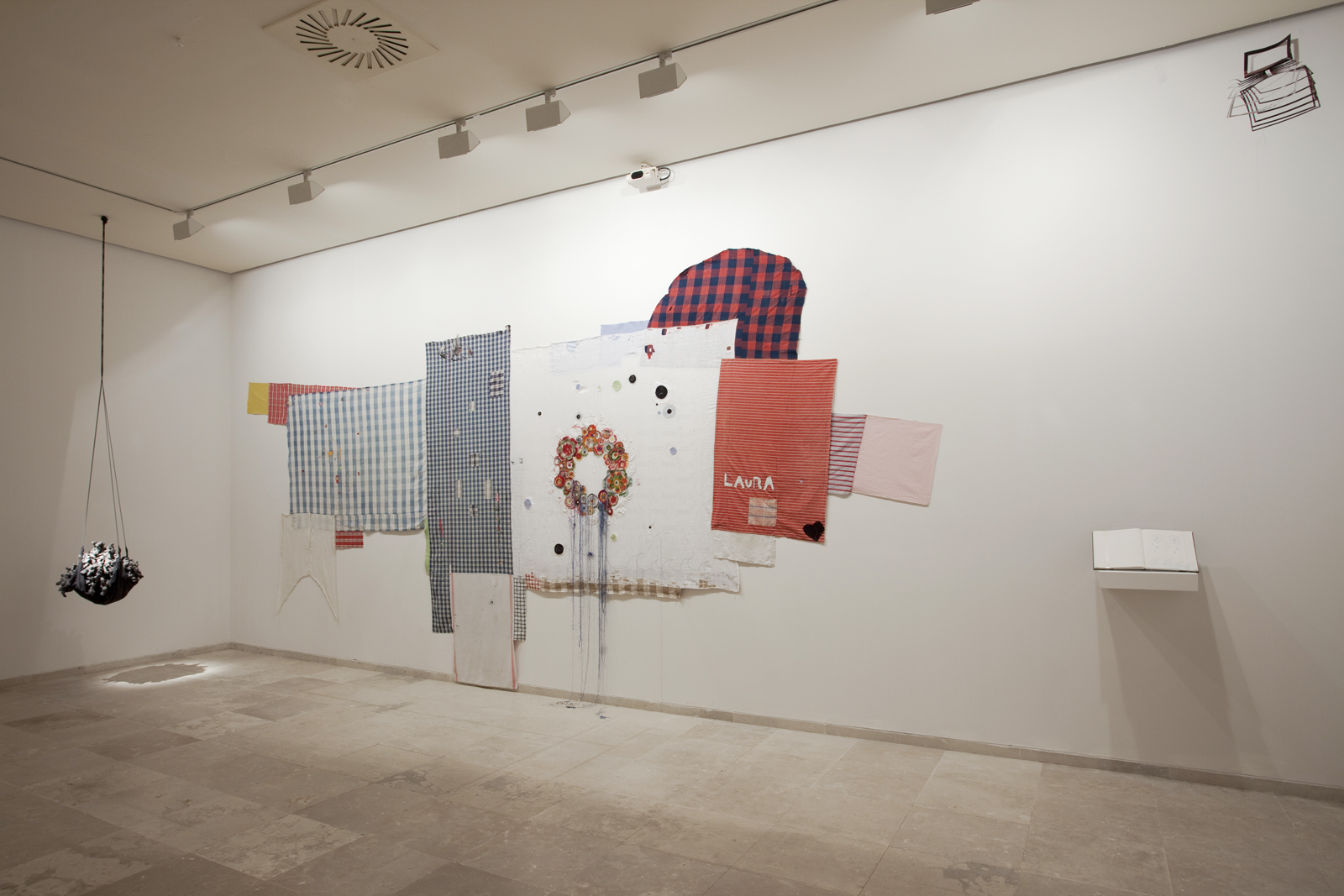 <p>Laura at the dinner table (2013), darned/embroidered family linens and drawing journal, 300cm x 500 cm;<br />
The Making of Us (2012), black clay, rope, and leather, 60cm diam.</p>
