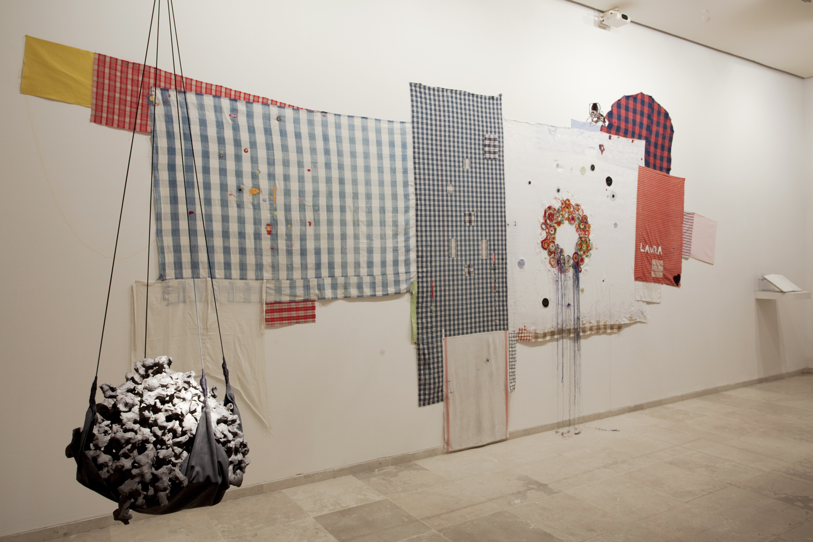 <p>Laura at the dinner table (2013), darned/ embroidered family linens and drawing journal, 300cm x 500 cm;<br />
The Making of Us (2012), black clay, rope, and leather, 60cm diam.</p>
