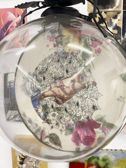 Self portrait embroidery encased in glass sphere and iron support (1997)